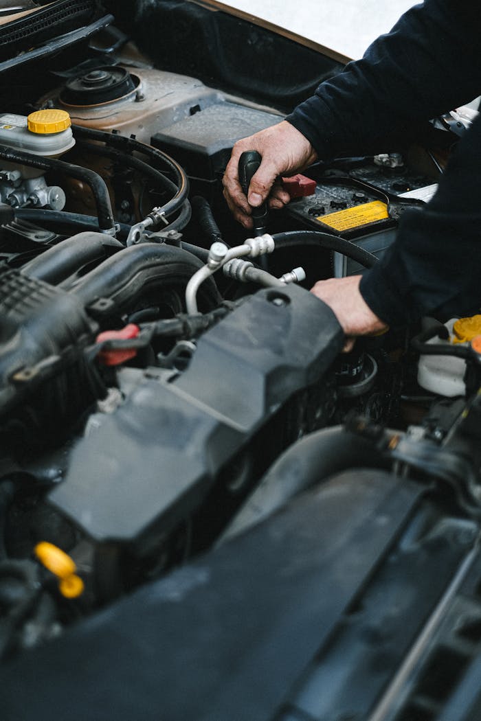 An Auto Mechanic Repairing the Engine of a Car