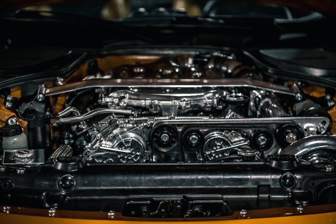 From above of polished stainless engine and automobile apparatuses under hood of new car